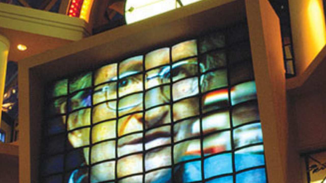 tv screens with a man with glasses